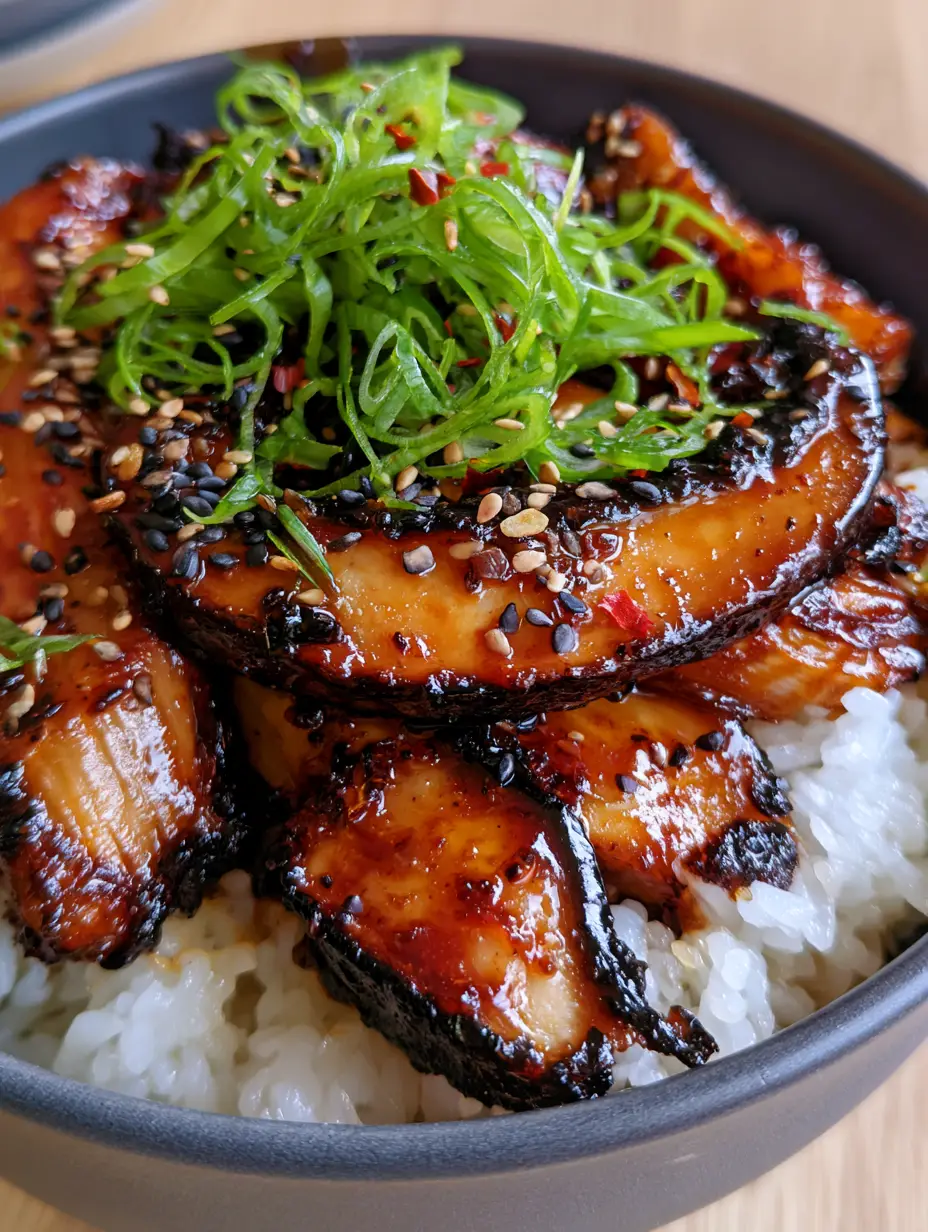 Extreme close-up of charred shiitake and king oyster mushrooms with a dark amber teriyaki glaze over steaming jasmine rice. (Teriyaki mushrooms and rice bowl)