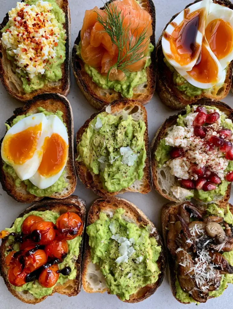 Close up of jammy eggs and blistered cherry tomatoes on thick avocado toast ideas.