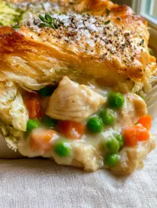 A macro extreme close-up of a thick slice of chicken pie being lifted, showing flaky layers and creamy gravy. (pie)