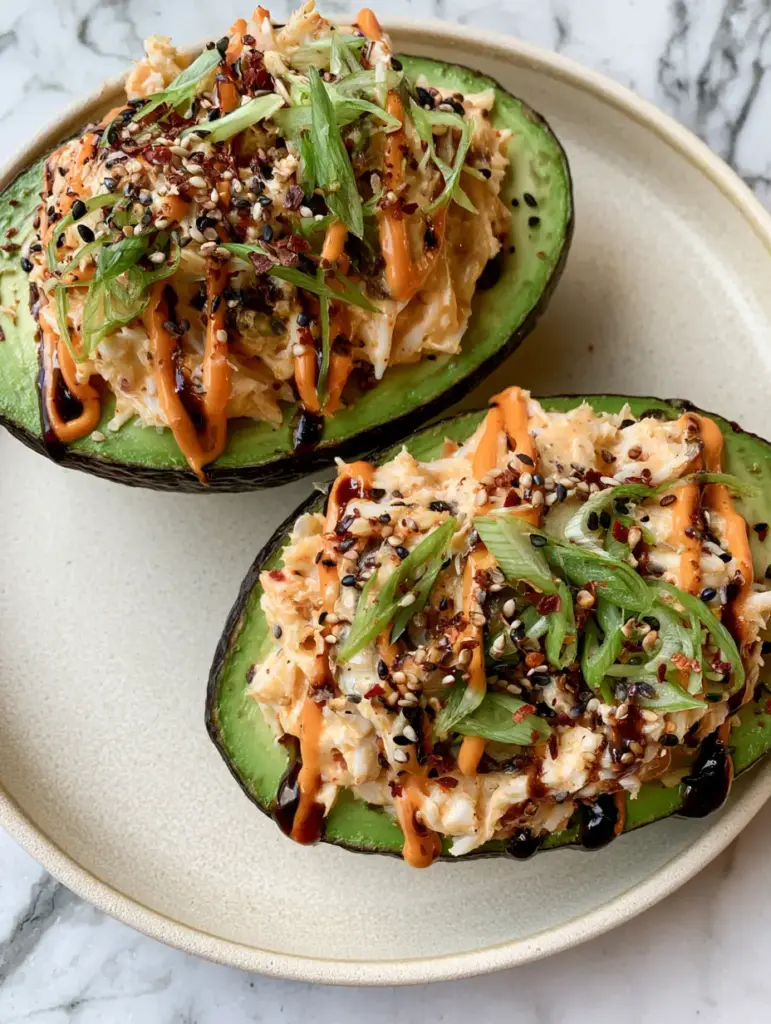 A handheld smartphone photo of two large avocado halves filled with creamy spicy crab on a cream plate. (spicy crab stuffed avocado)