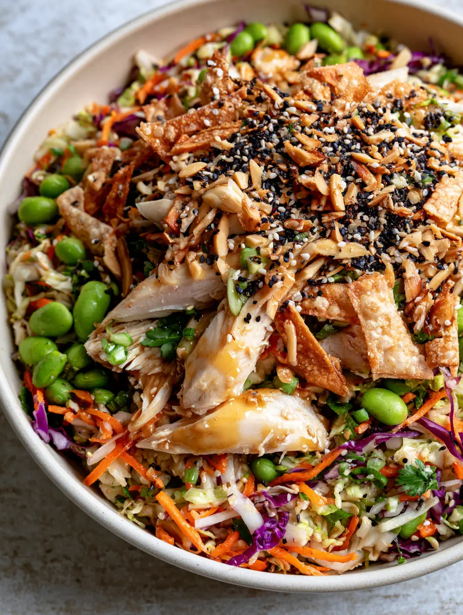 Asian Crunch Chicken Salad with Honey Ginger Vinaigrette 3 Macro view of Asian crunch chicken salad showing the texture of black sesame seeds, shredded red cabbage, and honey-colored vinaigrette.