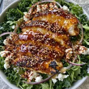 Smartphone photography of honey hot chicken salad with deep golden-brown chicken slices and glistening amber glaze.