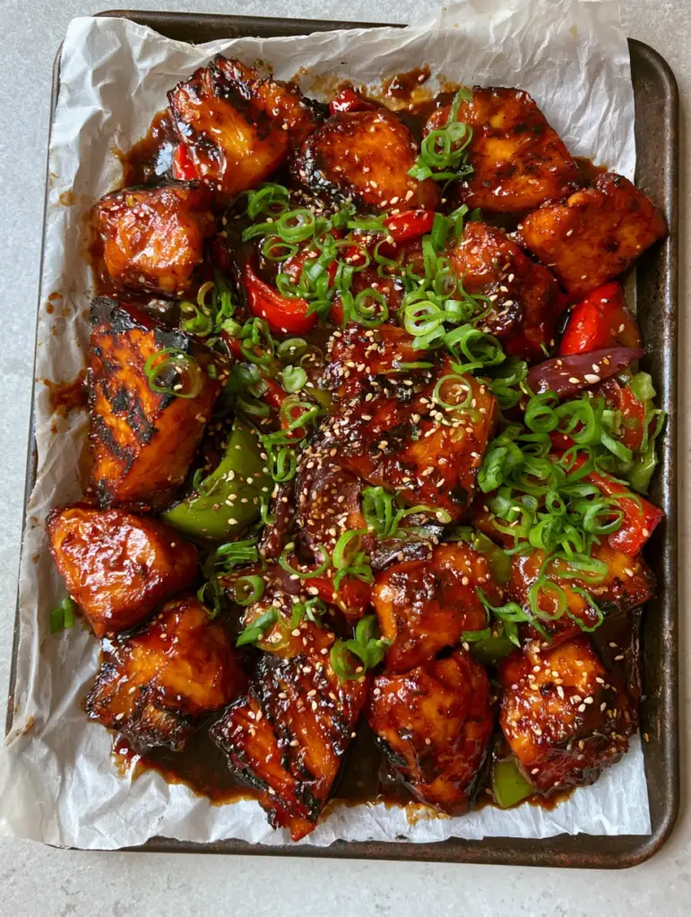 Gluten-free Hawaiian Chicken: The Ultimate Sheet Pan Island Feast 1 Close up of caramelized pineapple wedges with dark brown grill marks and charred red bell peppers in Gluten-free Hawaiian Chicken.