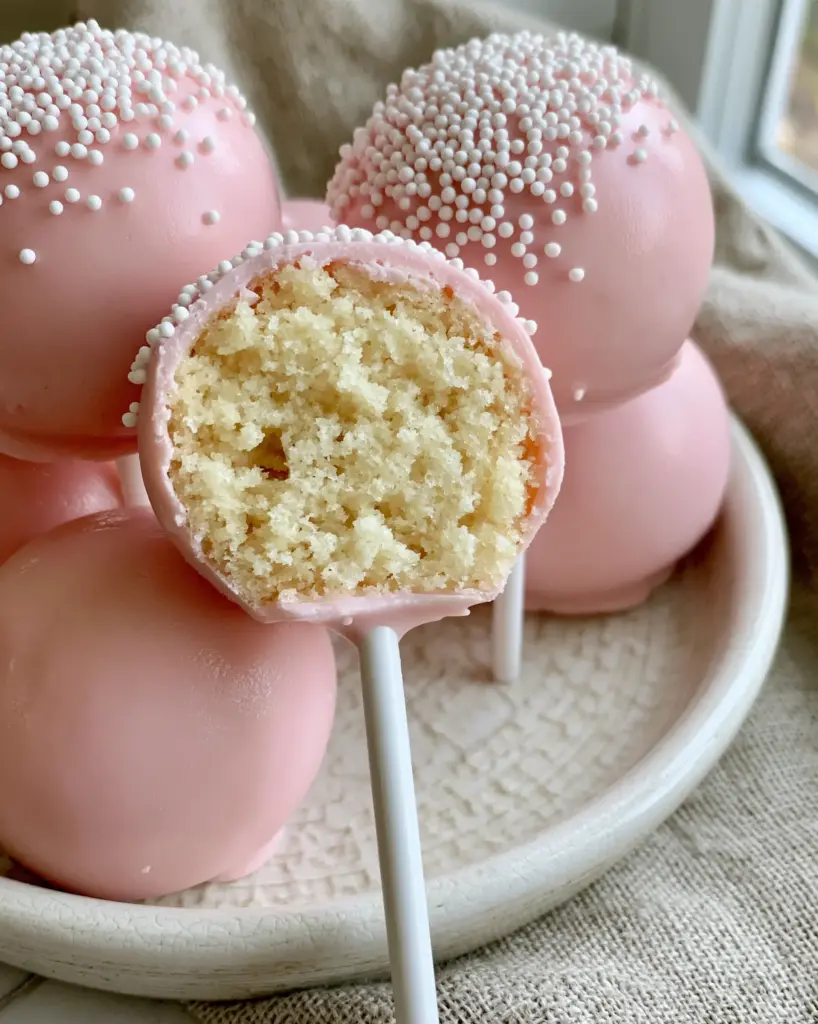 Cake Pop Recipes: The Ultimate Guide to Perfect Pink Copycat Treats 2 A close-up shot showing a clean bite into a moist pale-yellow vanilla cake pop interior. (cake pop recipes)